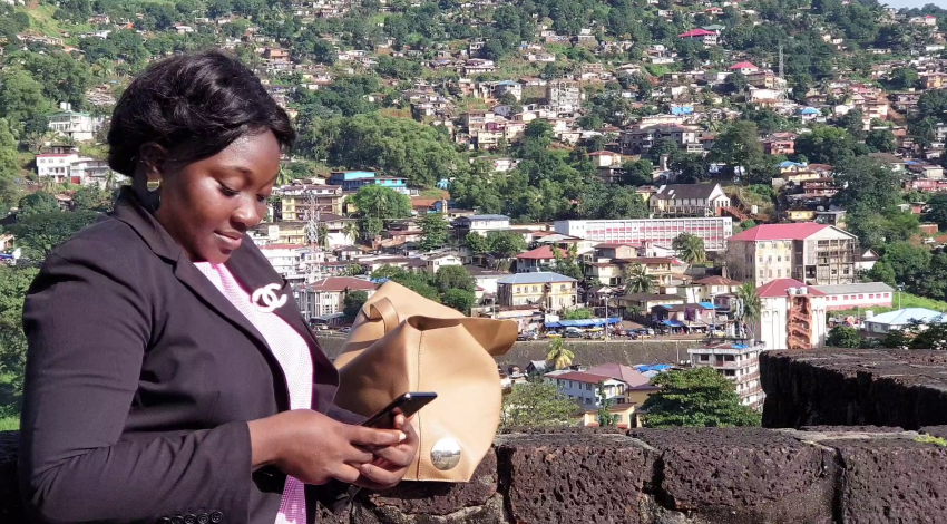 A woman holding and looking at a phone