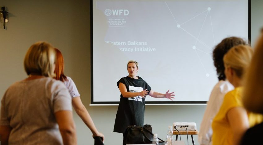 A woman giving a presentation about a democracy initiative in Western Balkans