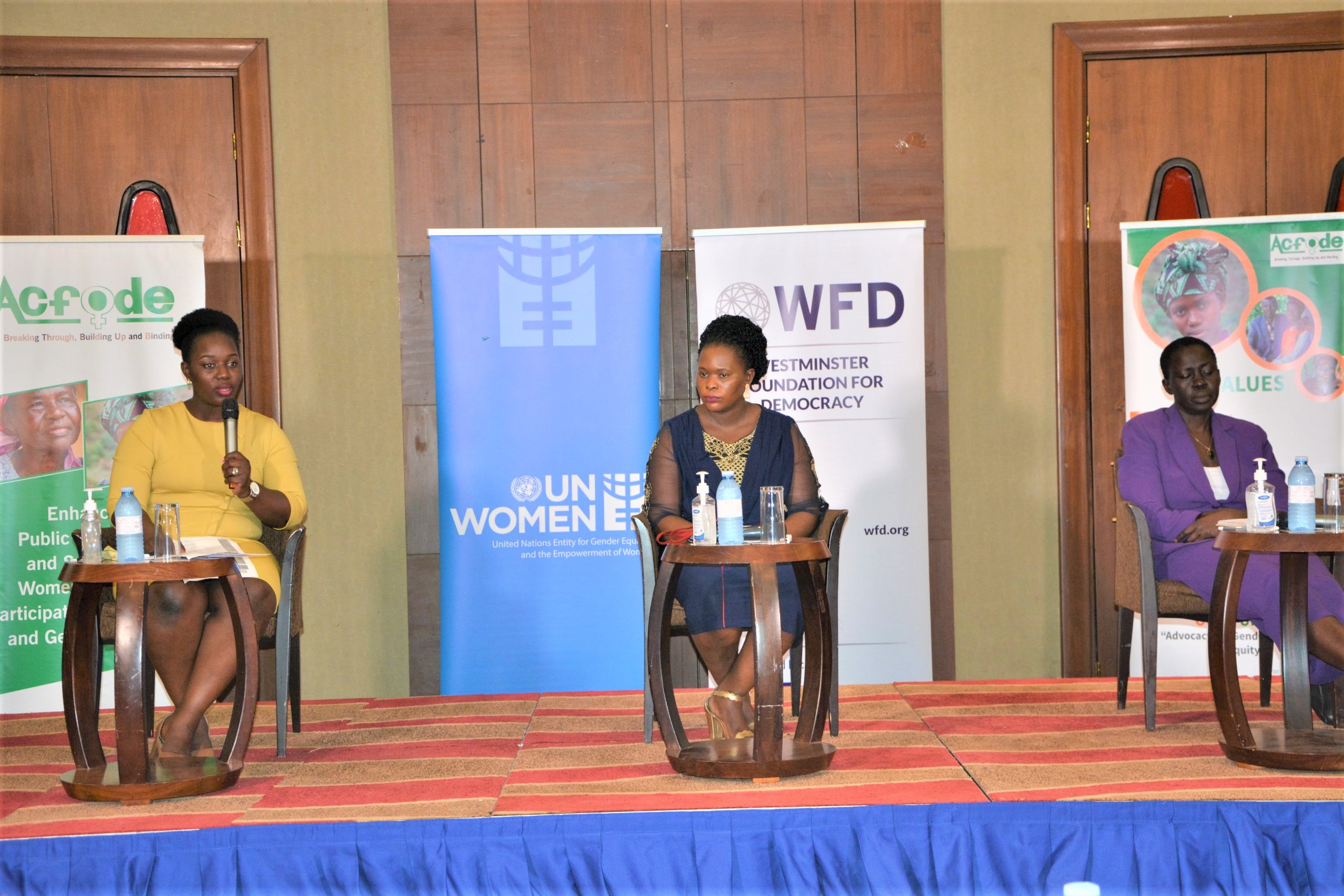 Three women sitting in a podium during an event