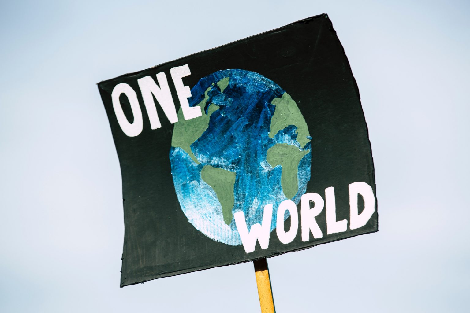 a protest banner reading one world