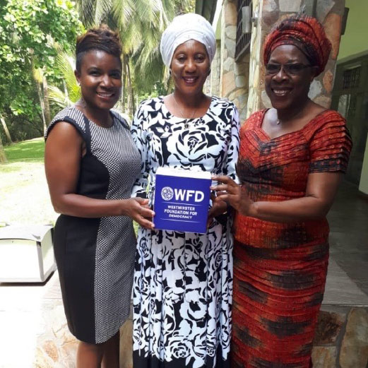 Three women smiling and all holding a WFD branded box