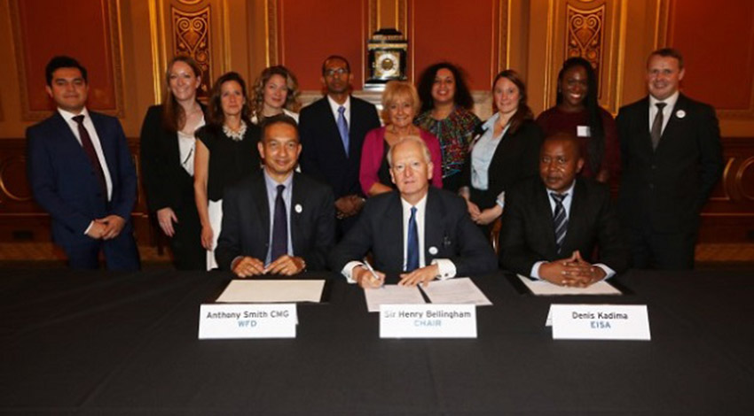 Three people sitting as a group is standing behind them