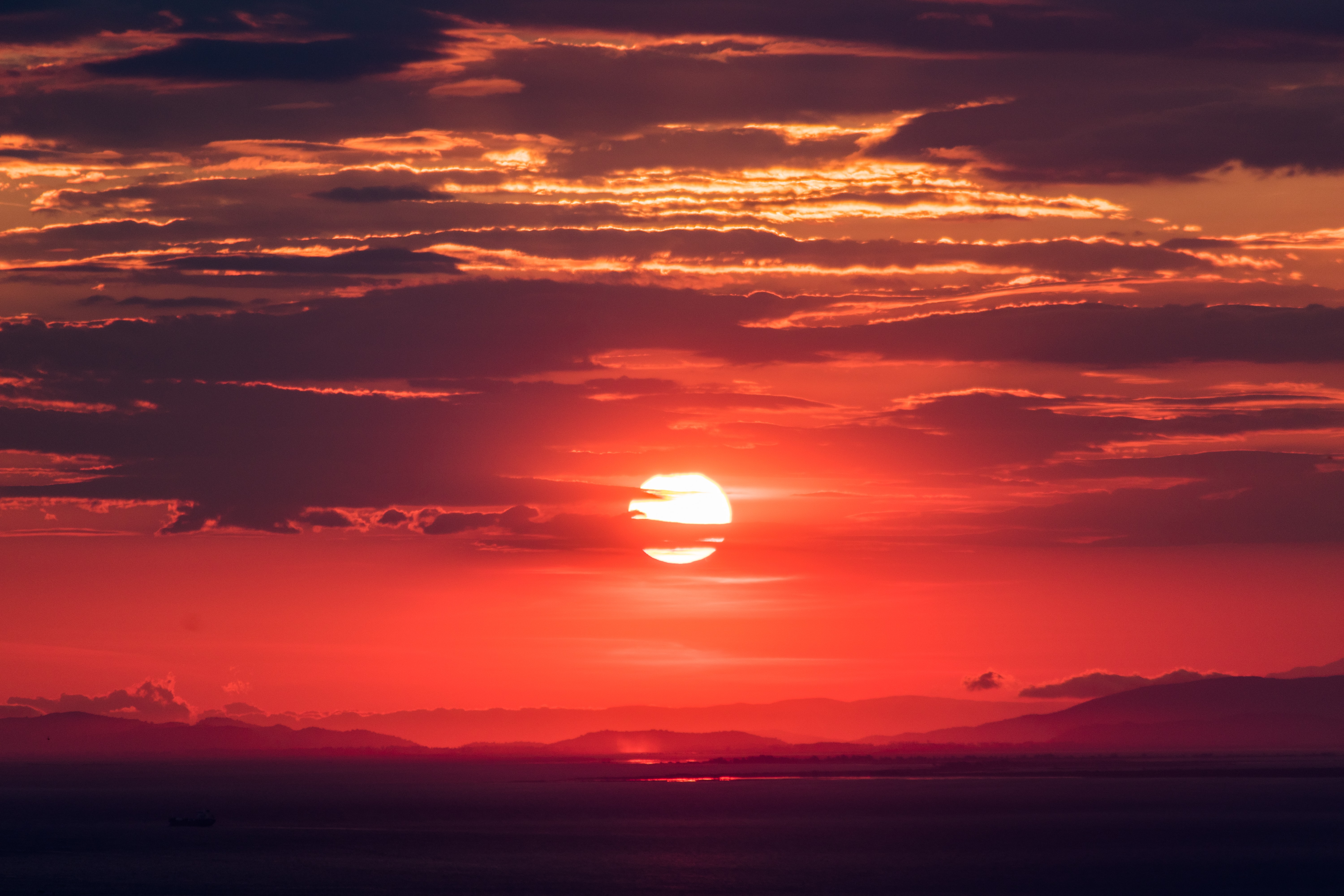 sun setting behind clouds