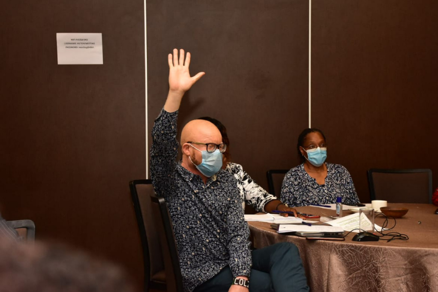 A man lifting his hand up in a meeting