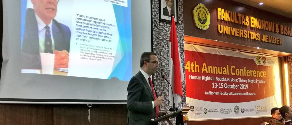 A man speaking on the stage at a conference about human rights