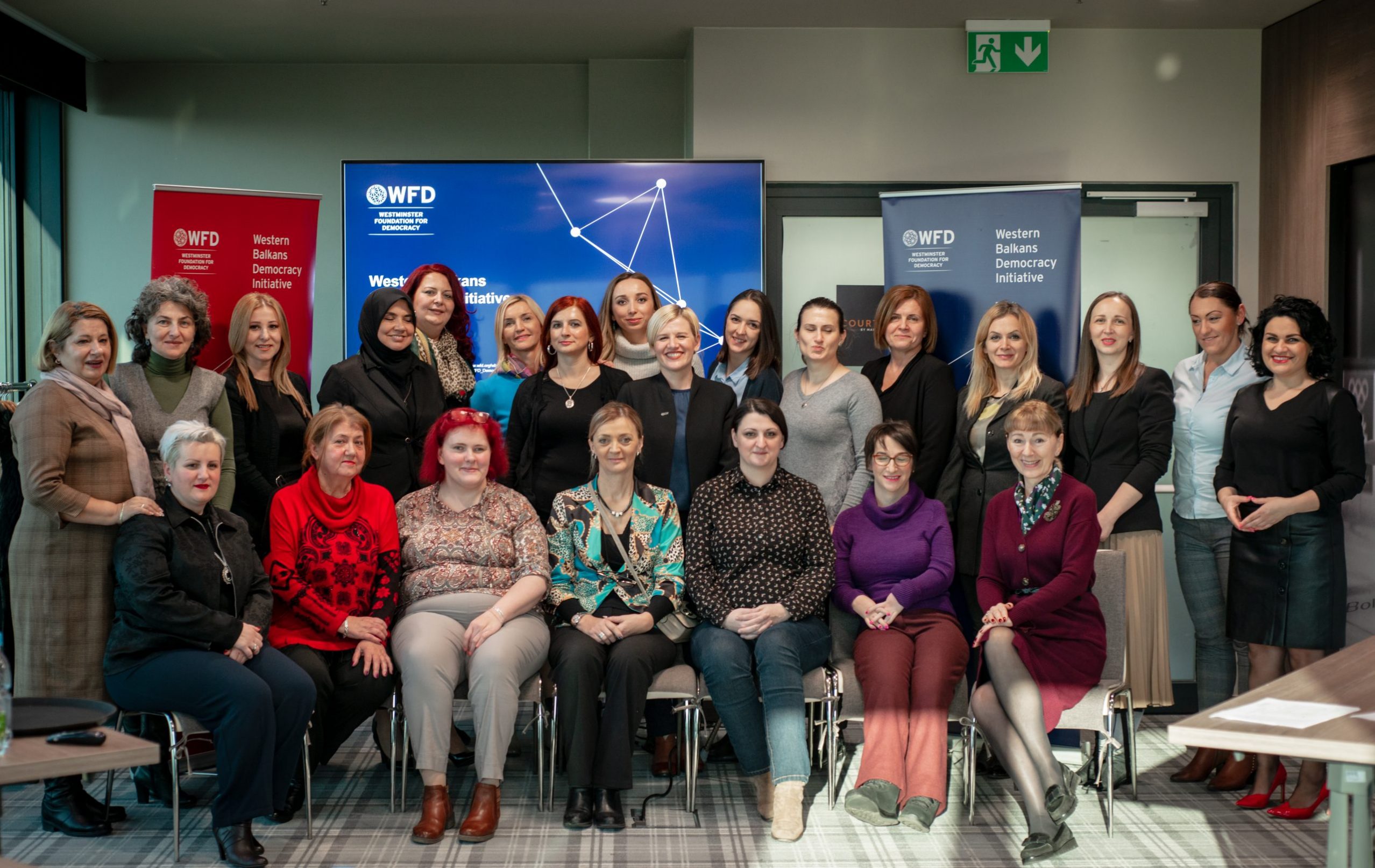 A group photo of programme participants smiling seating in rows