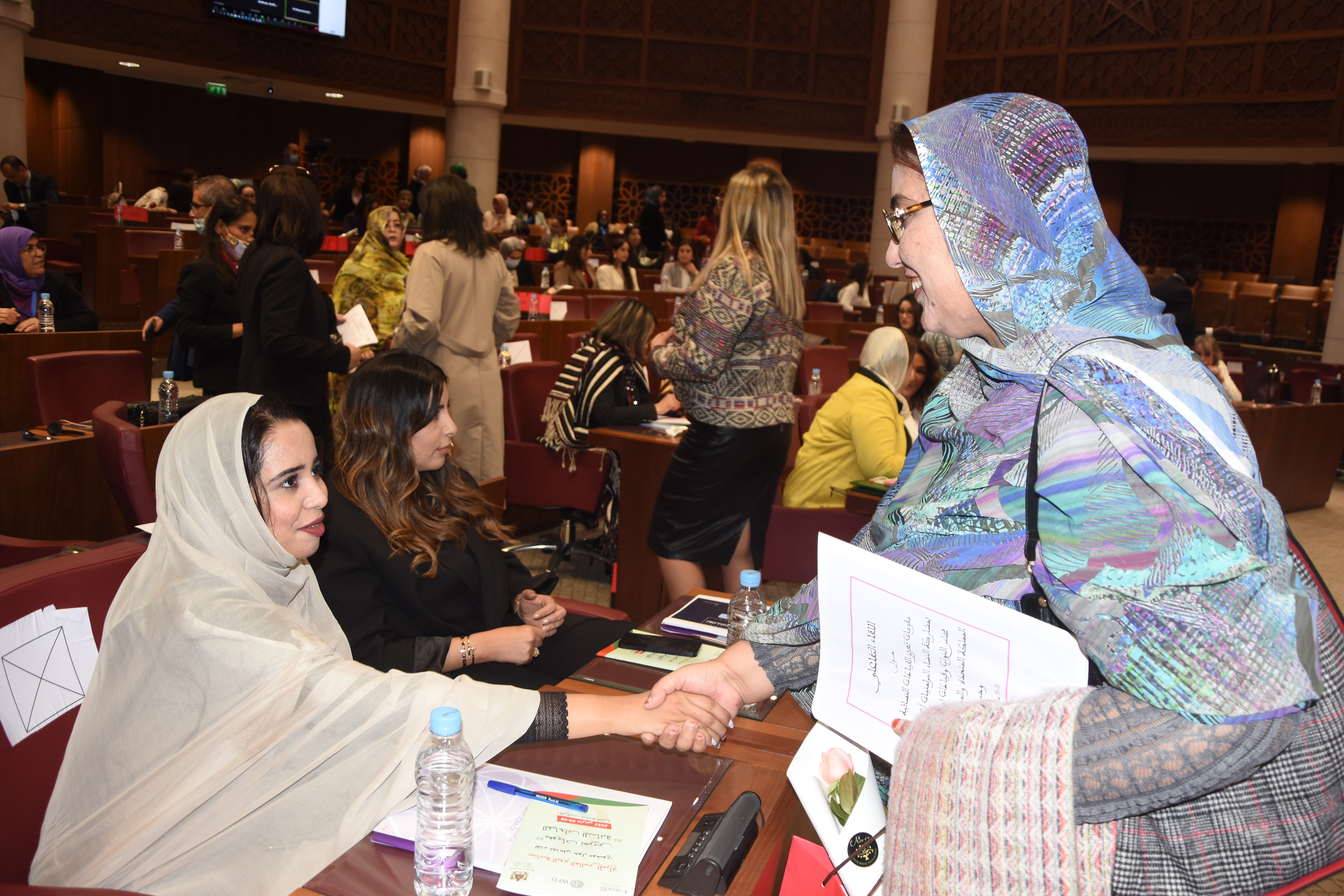 Two women shaking hands in the Moroccan Parliament