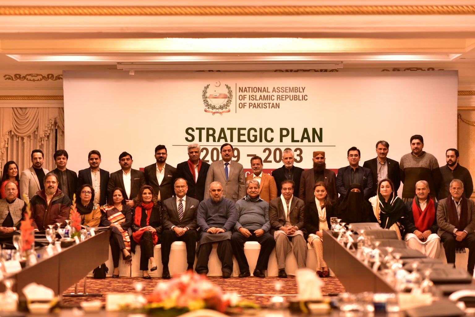 People sitting in rows in front of a sign saying strategic plan