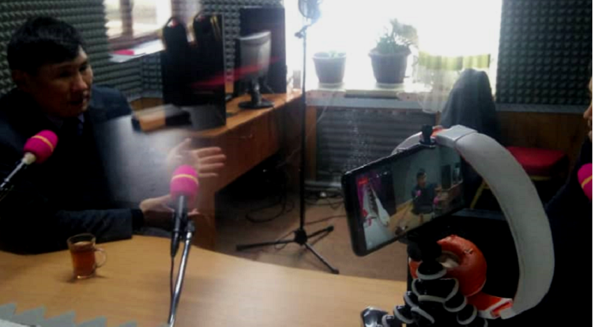 A man recording himself using a phone in a studio