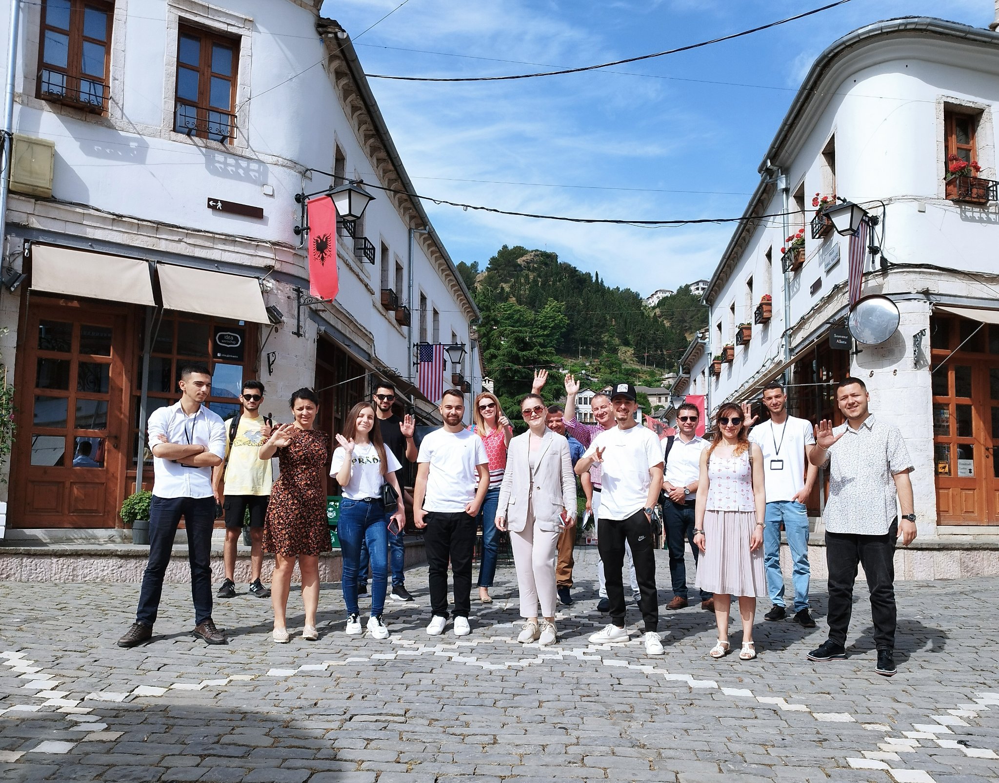 A group of people standing in the street smiling at the camera