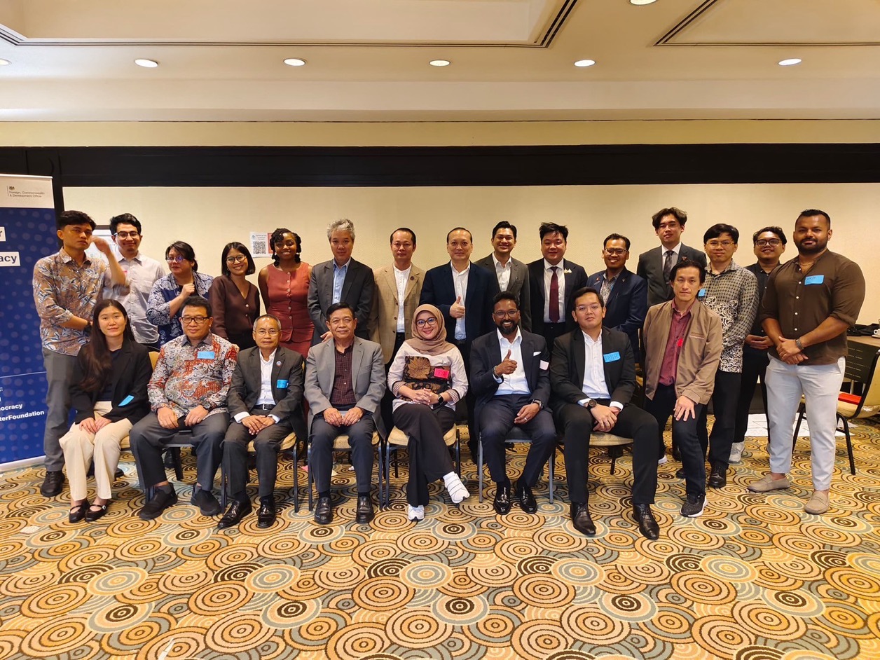 A group photo where a row of men and women are sitting and another row of men and women are standing behind them. 