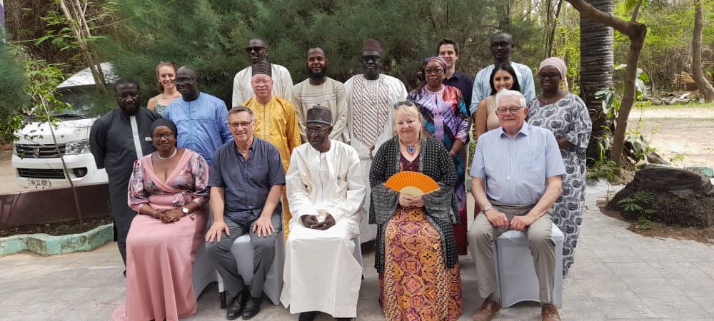 People posing sitting with others standing behind them