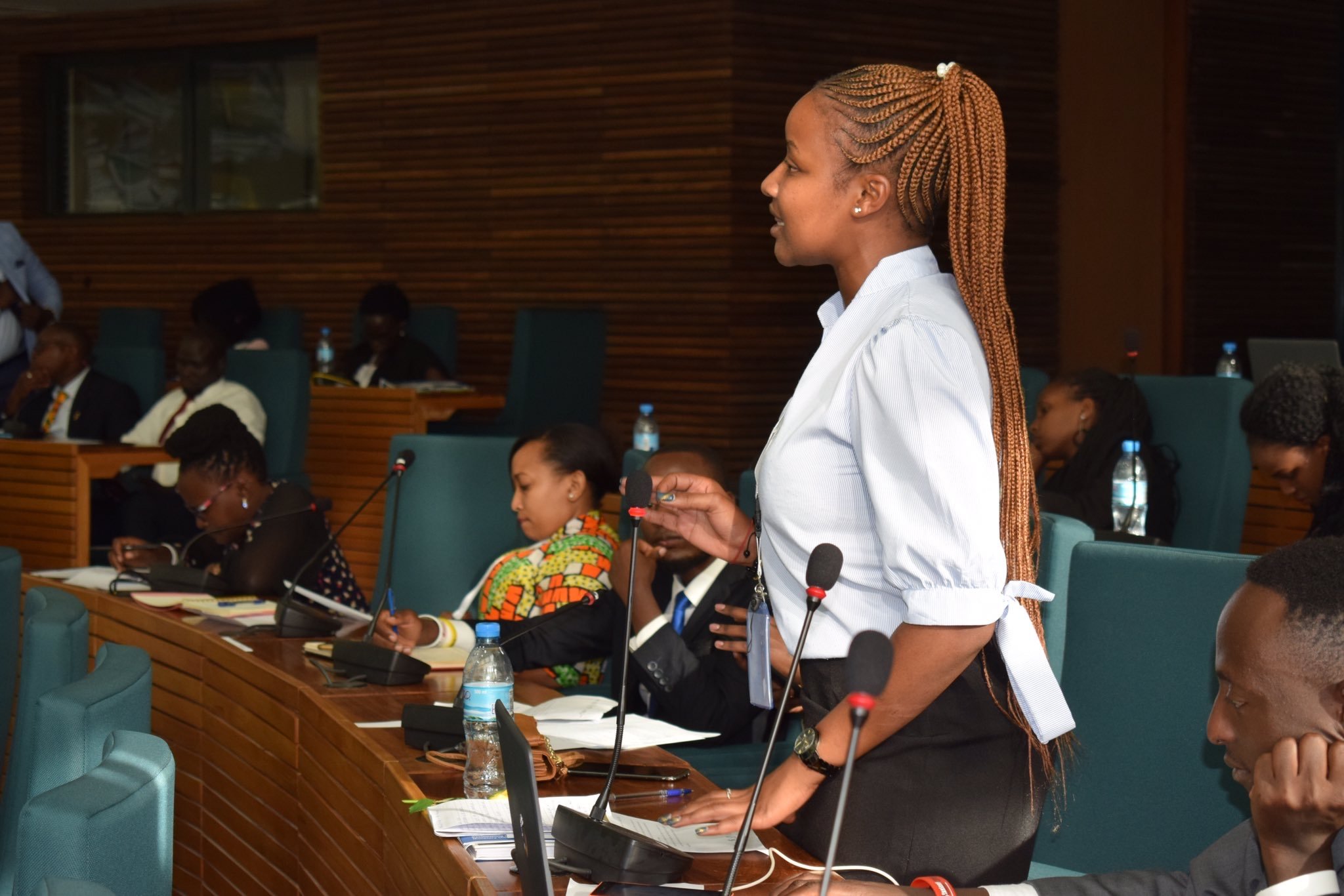 A young lady speaking in a meeting while standing