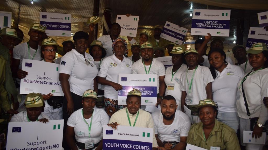 A group of people looking at the camera holding up signs saying youth voice counts