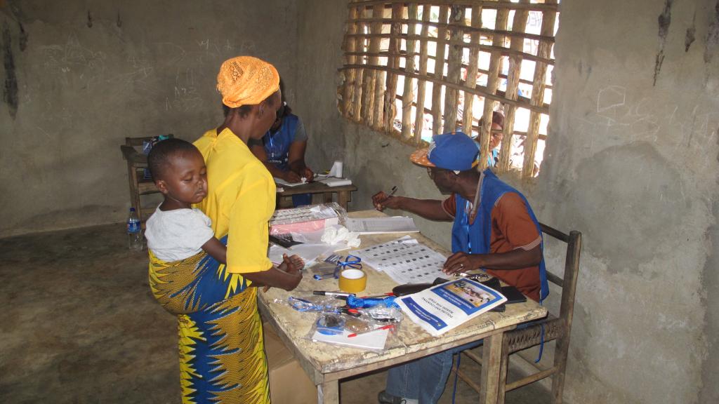 a person with a baby standing at a voting registration desk