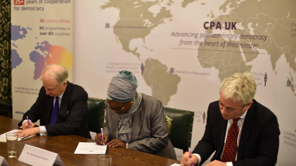Three people signing an MoU