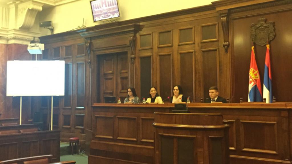 Four people sitting behind a bench in the parliament of Serbia