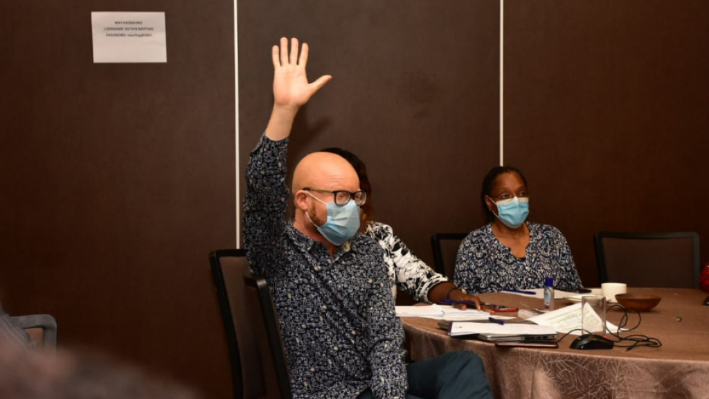 A man lifting his hand up in a meeting