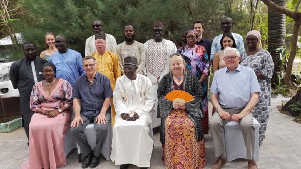 People posing while sitting with others standing behind them