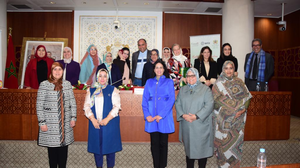 A group of women in the Moroccan Parliament smiling at the camera