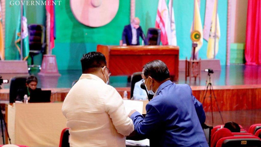 Two men examine a document in a session of the Bangsamoro Transition Authority