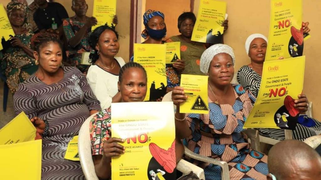 Group pf people posing while holding a placard