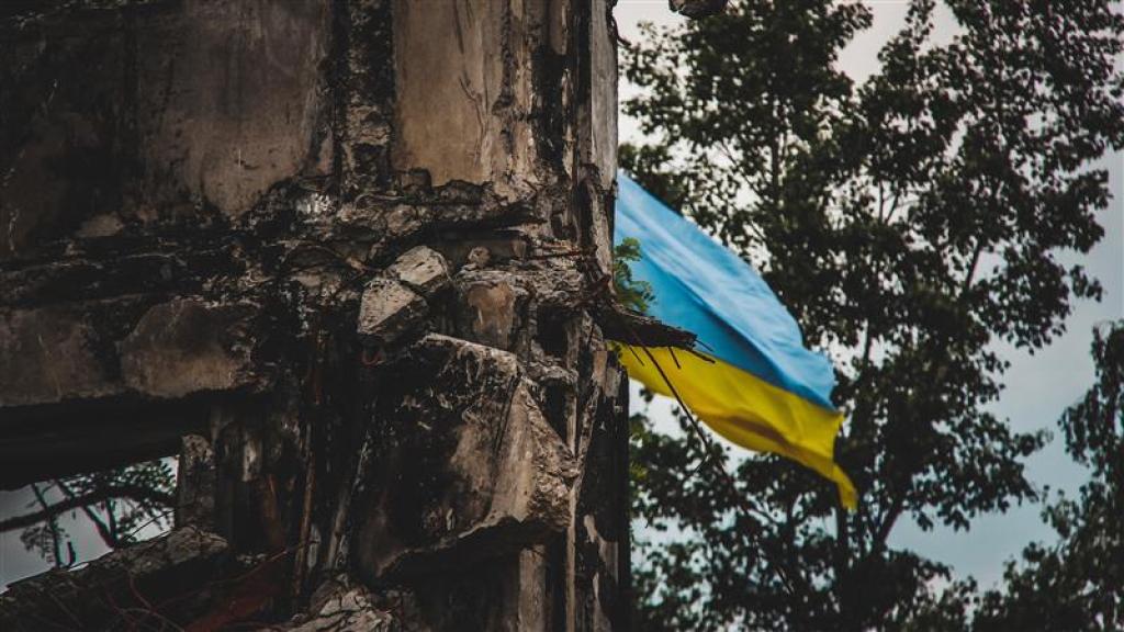 Flag of Ukraine flying near a destroyed building