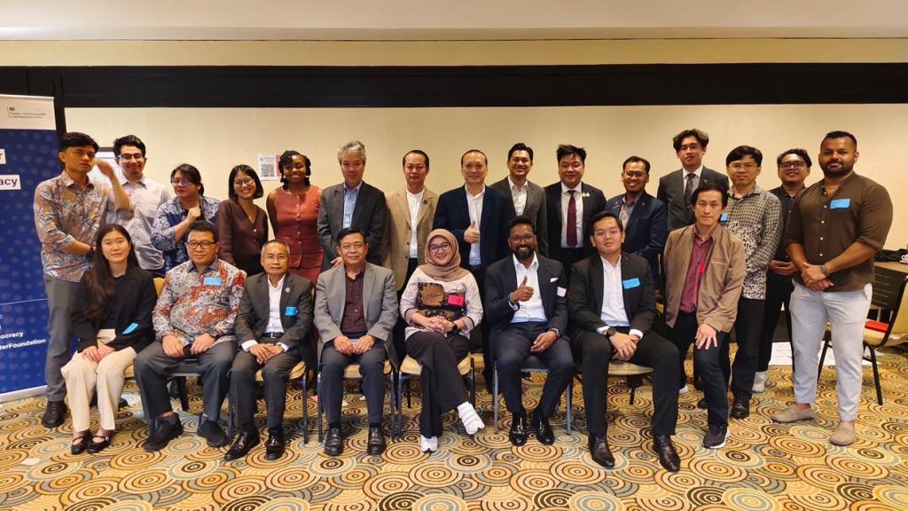 A group photo where a row of men and women are sitting and another row of men and women are standing behind them. 