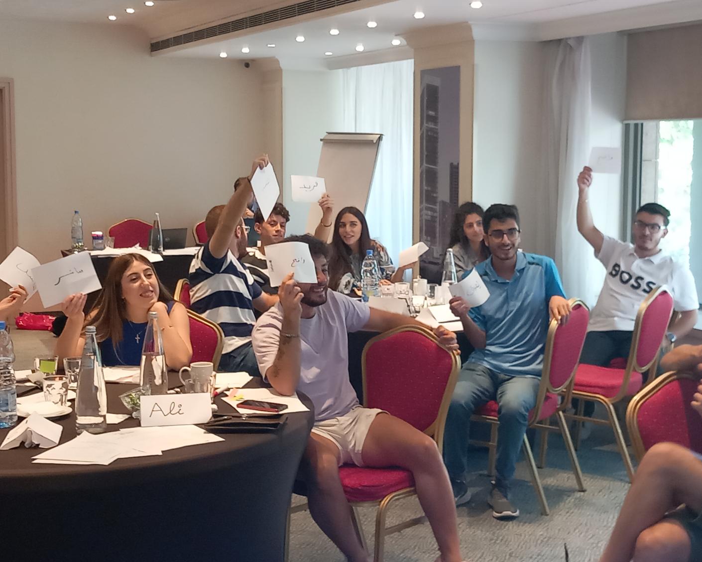 Youth in Lebanon lifting papers in a meeting