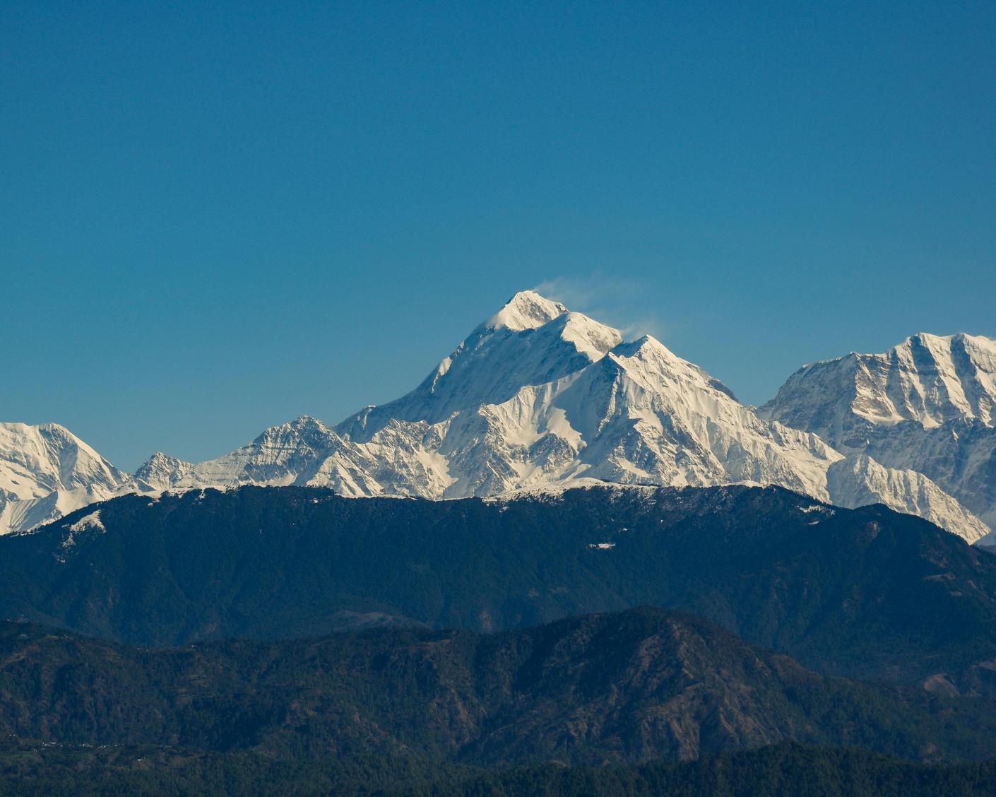 Snow covered mountain peaks against blue sky
