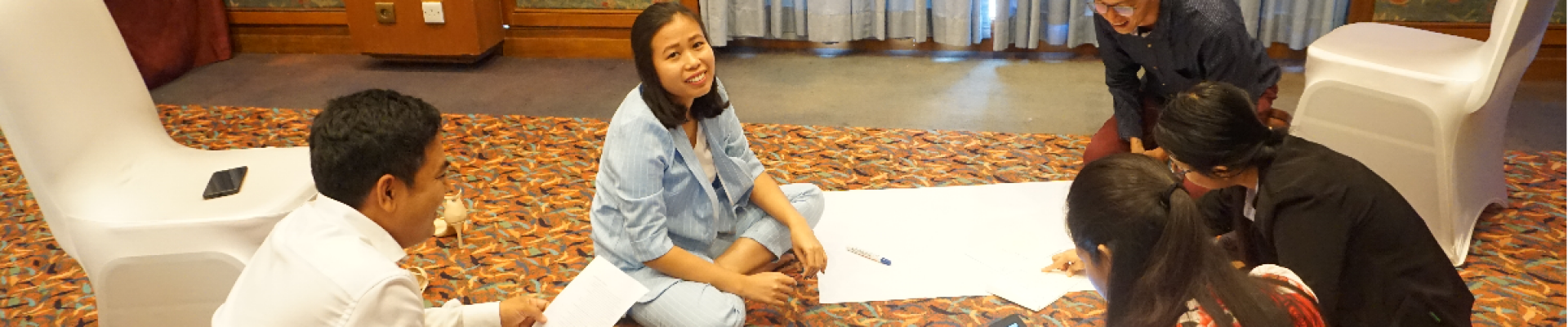 People sitting round a piece of paper working together