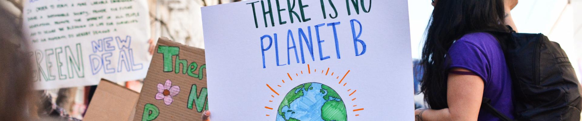 Protestors holding up a sign that says there is no planet B