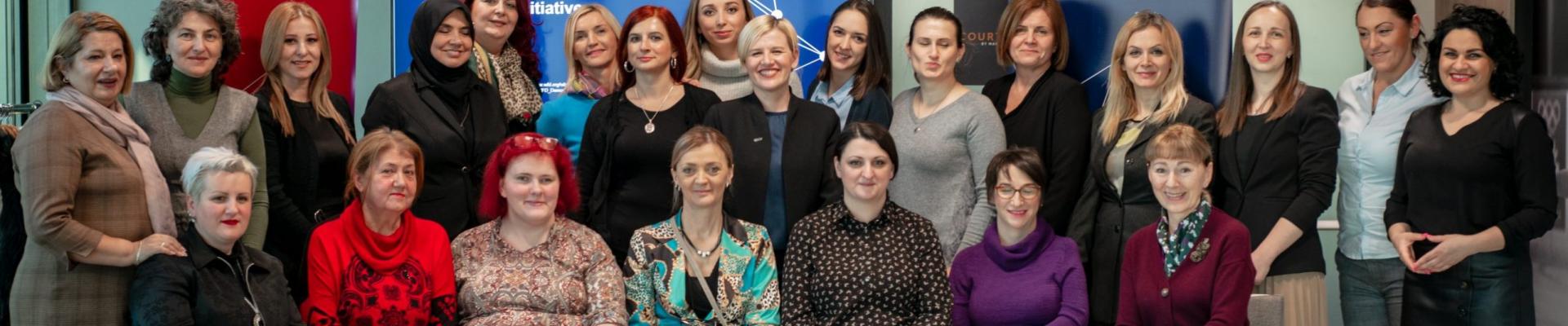 A group photo of programme participants smiling seating in rows