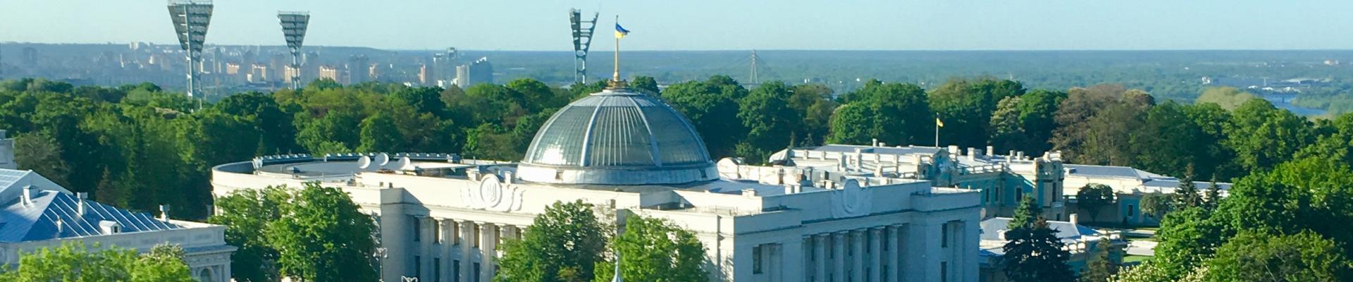 The Verkhovna Rada of Ukraine with the Ukrainian flag flying above the dome on a sunny day