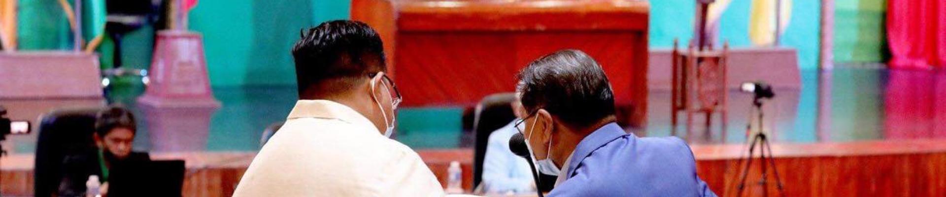 Two men examine a document in a session of the Bangsamoro Transition Authority