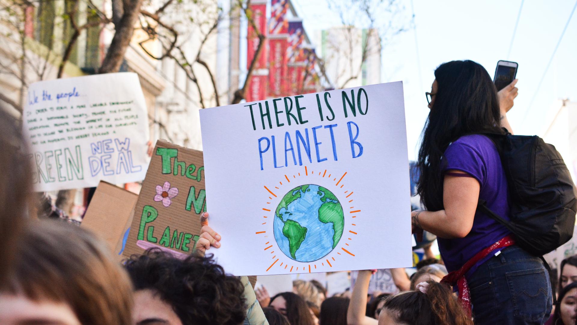 Protestors holding up a sign that says there is no planet B