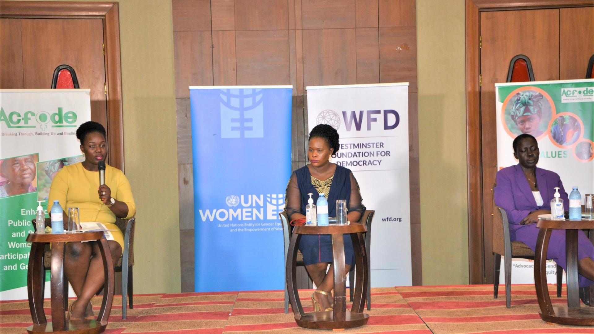 Three women sitting in a podium during an event