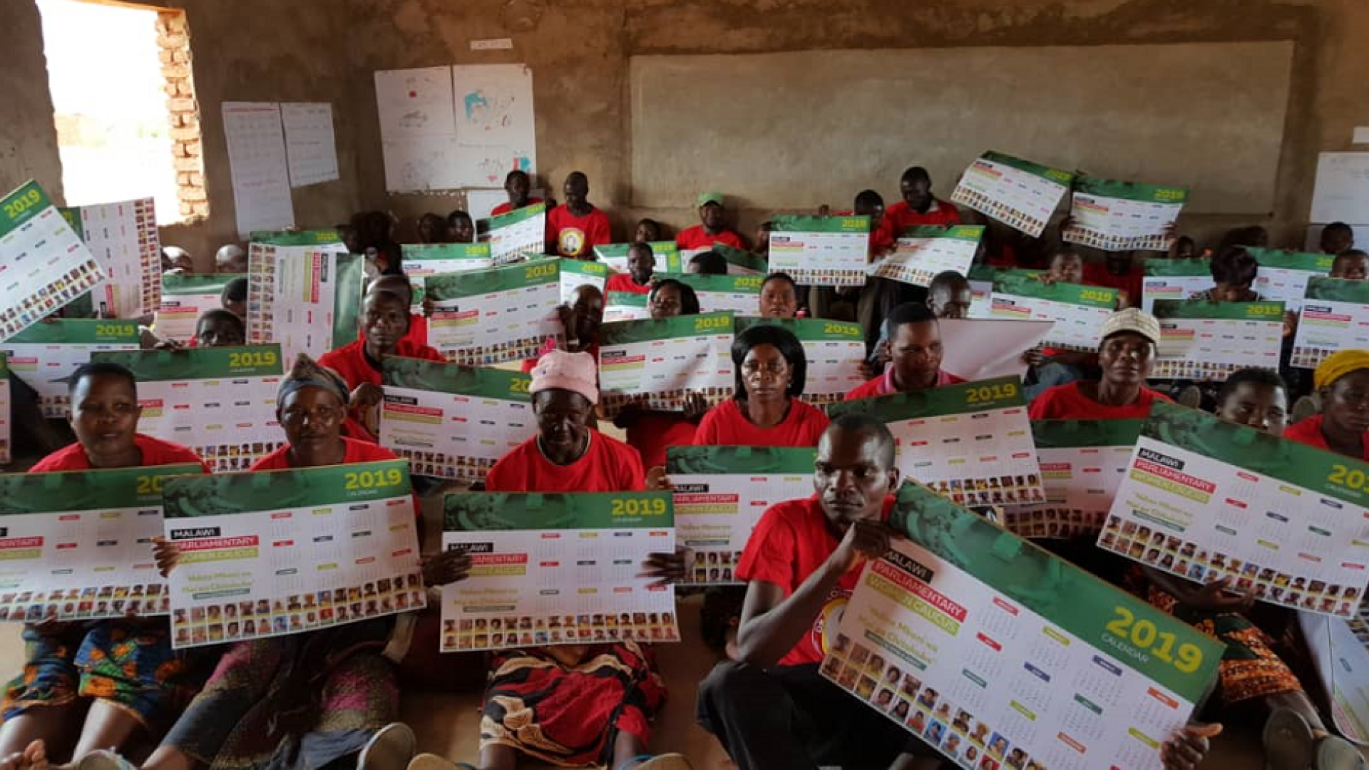 Group of people holding placards while sitting