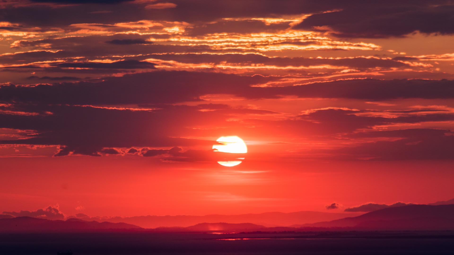 sun setting behind clouds