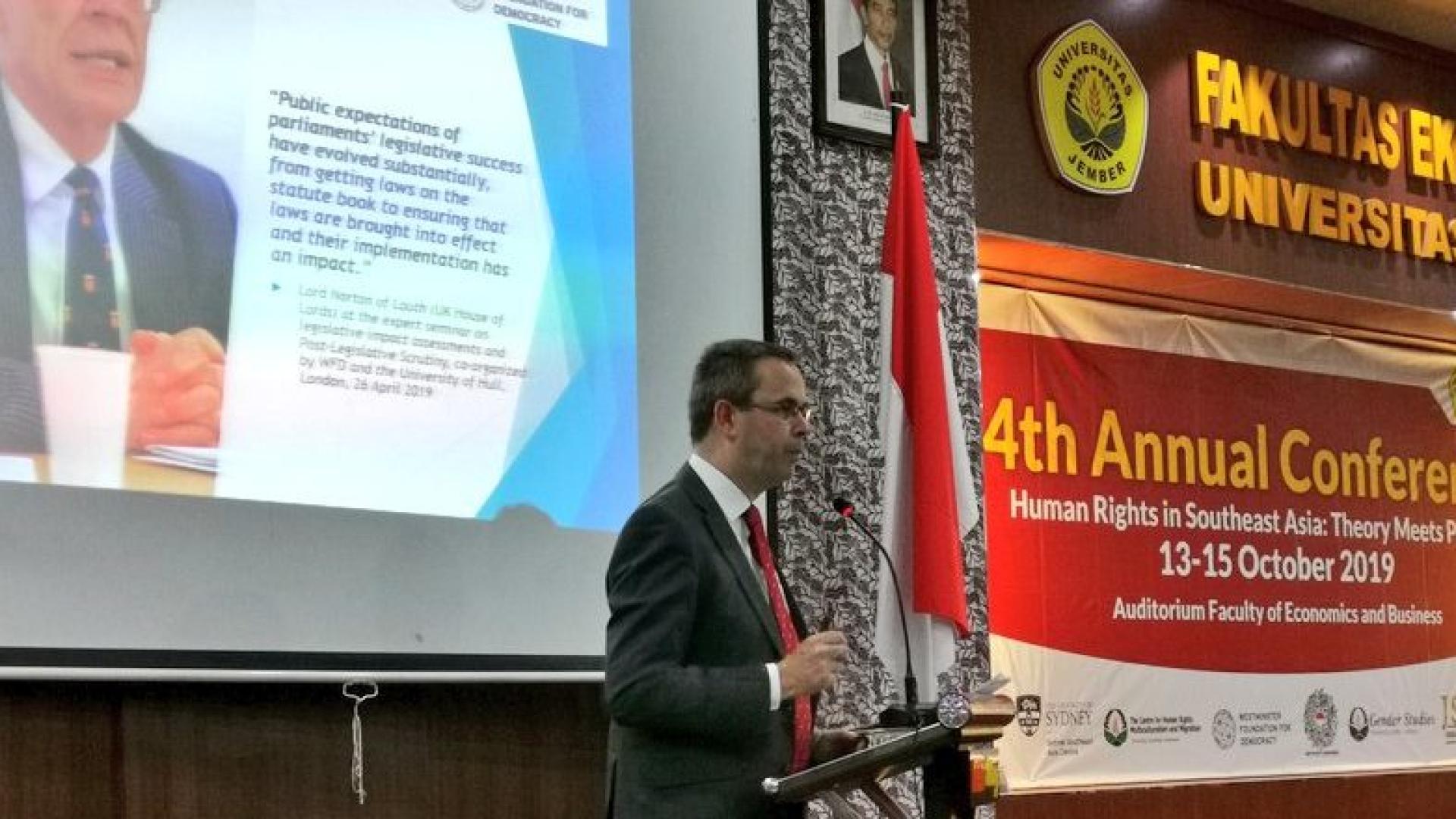 A man speaking on the stage at a conference about human rights