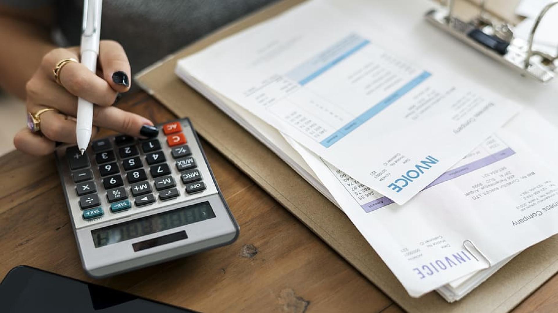 A hand of a person using a calculator 