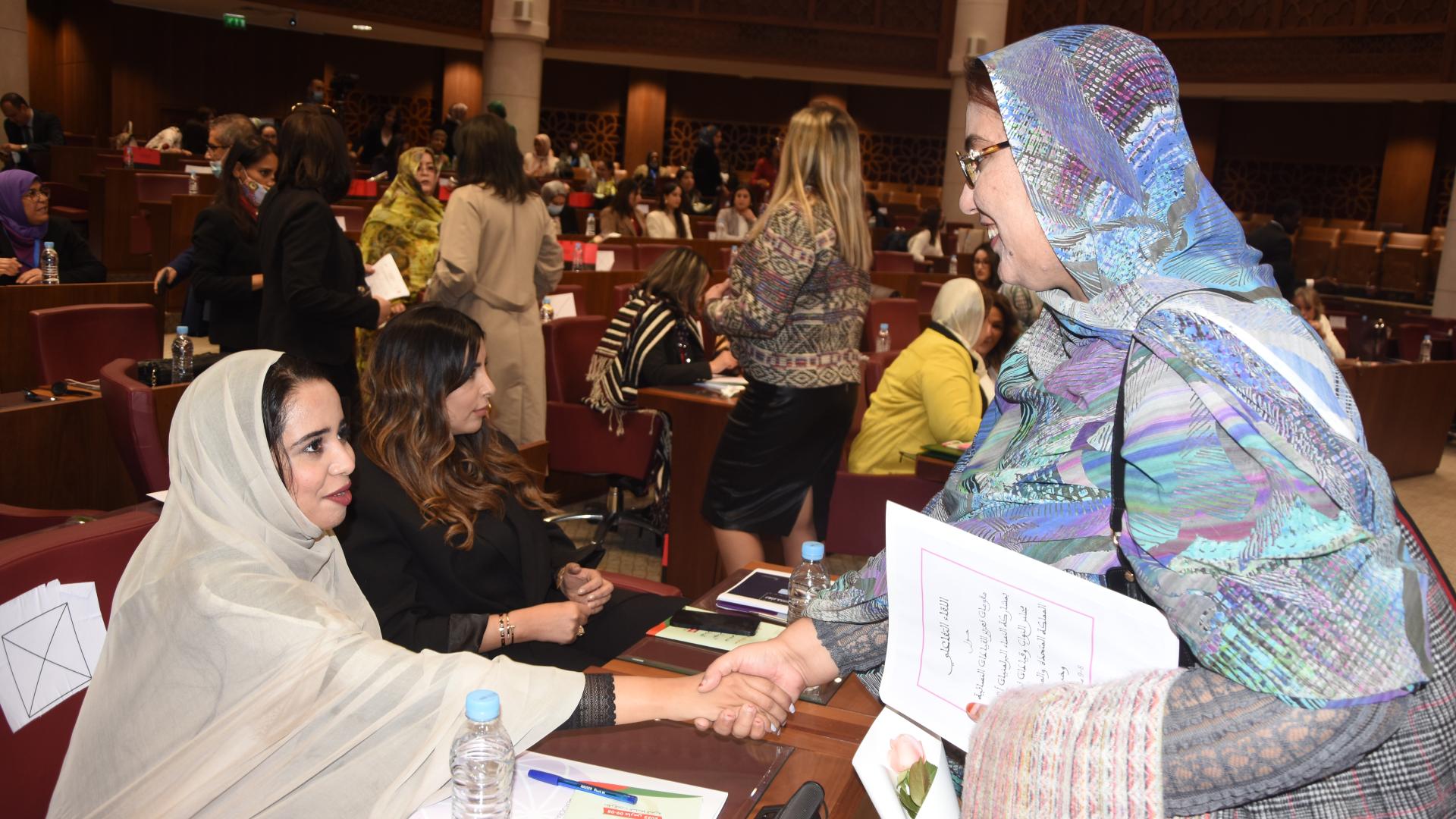 Two women shaking hands in the Moroccan Parliament