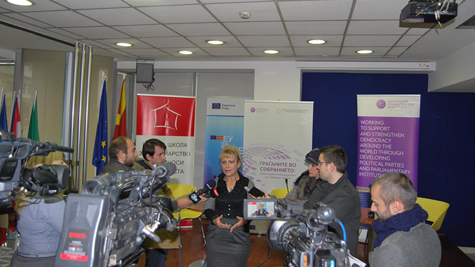 a woman speaking into media microphones and cameras