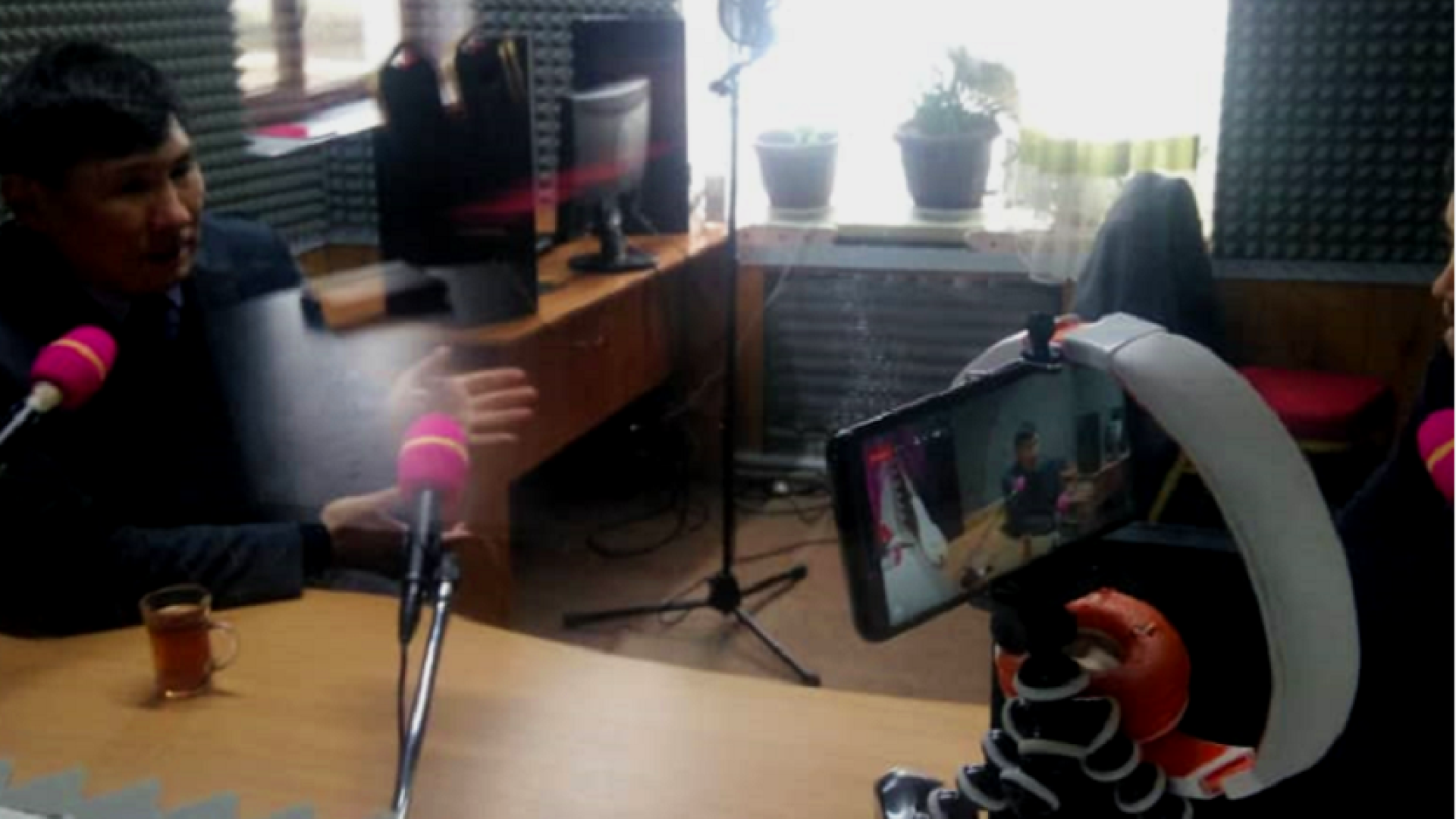 A man recording himself using a phone in a studio