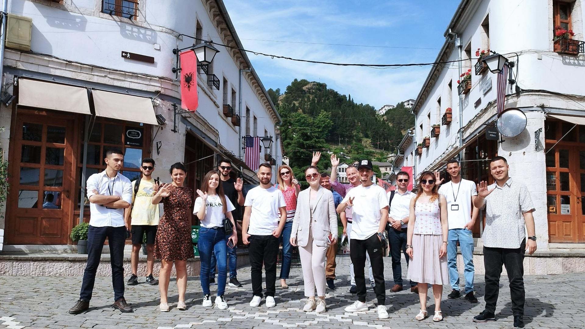 A group of people standing in the street smiling at the camera