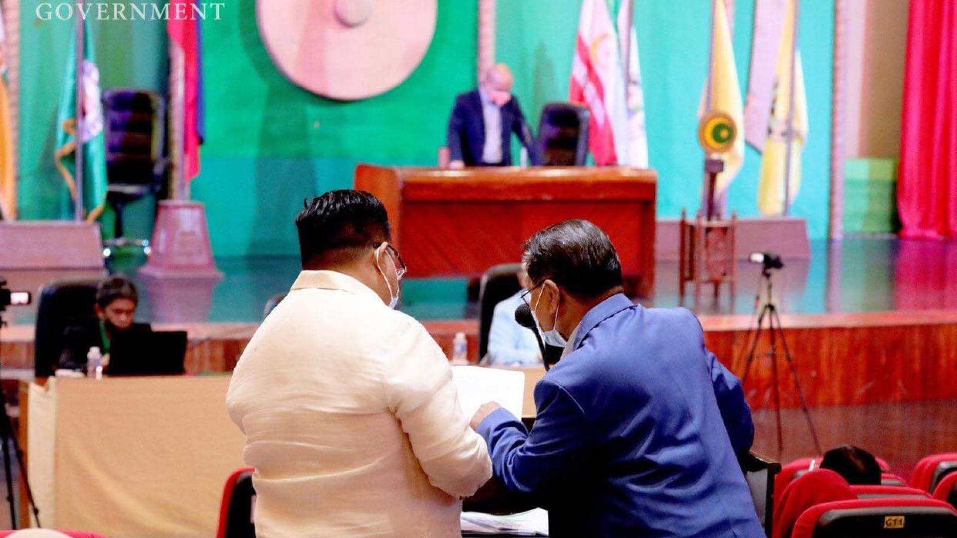 Two men examine a document in a session of the Bangsamoro Transition Authority