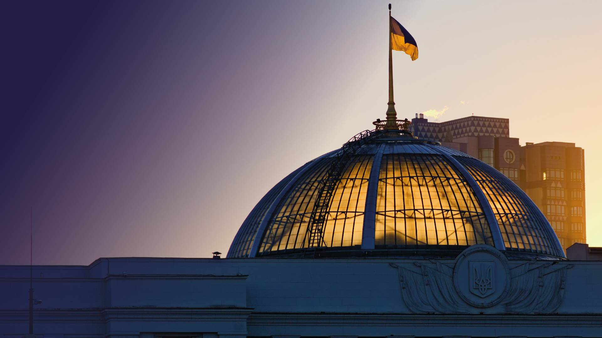 The sun coming through the dome of the Parliament of Ukraine, with the Ukrainian flag flying above