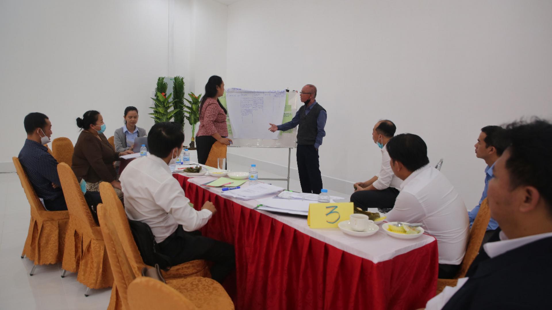 Two people standing to present in a group meeting