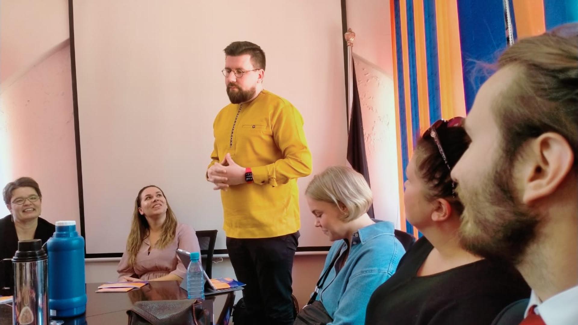 A person talking to a sitting audience while standing