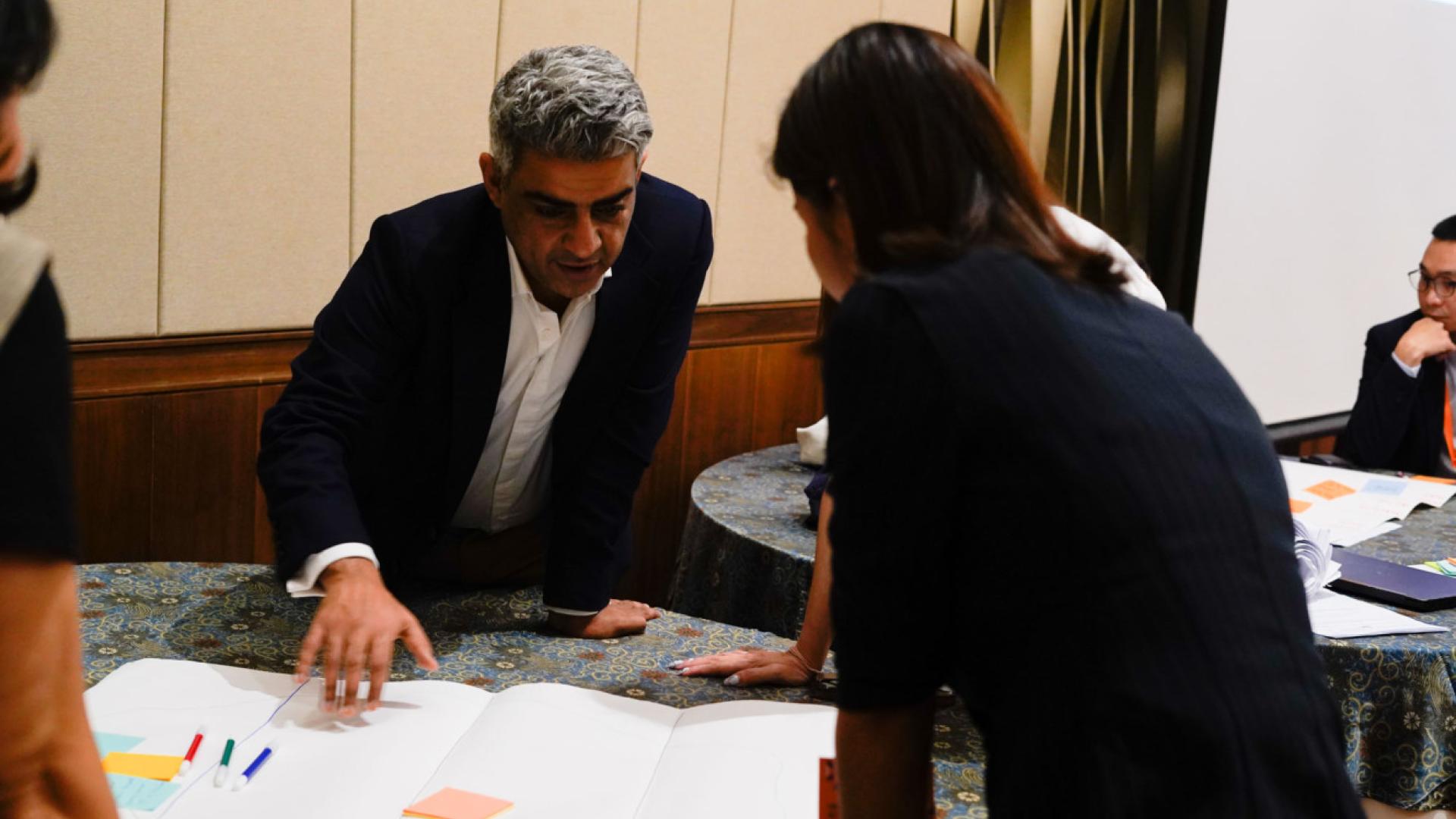 A man and a woman look at a sheet of paper